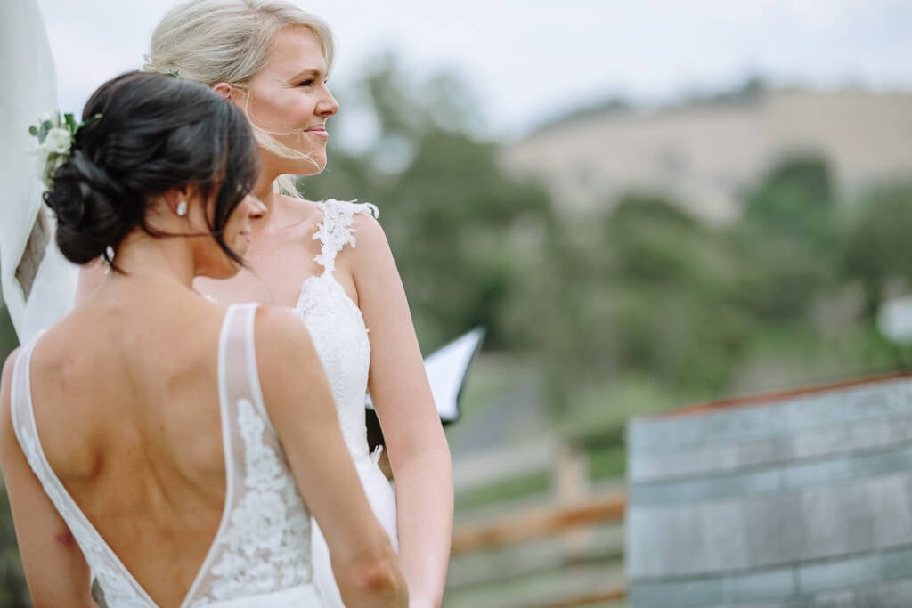 The couple look to the side during their commitment ceremony at Riverstone.