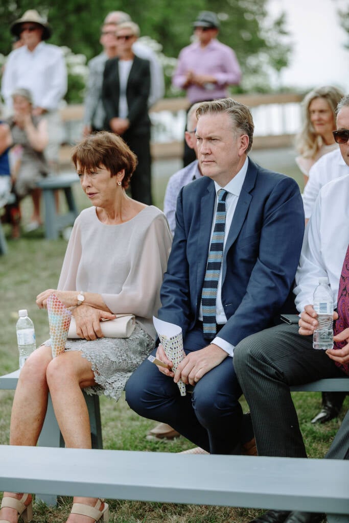 Seated guests hold confetti cones while watching the ceremony at Riverstone Estate.