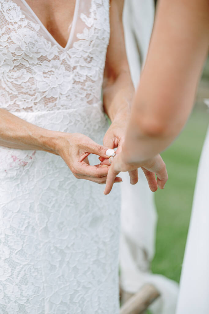 Ashlee places a ring on Kate's finger during their commitment ceremony at Riverstone.