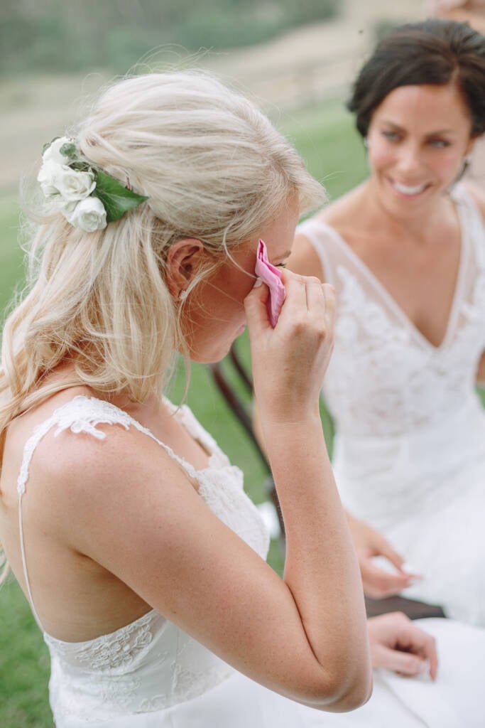 Kate dabs her eye with a pink handkerchief as Ashlee smiles beside her.