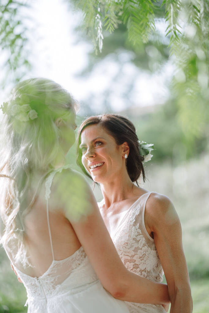 Ashlee smiles at Kate through foreground leaves at Riverstone Estate.