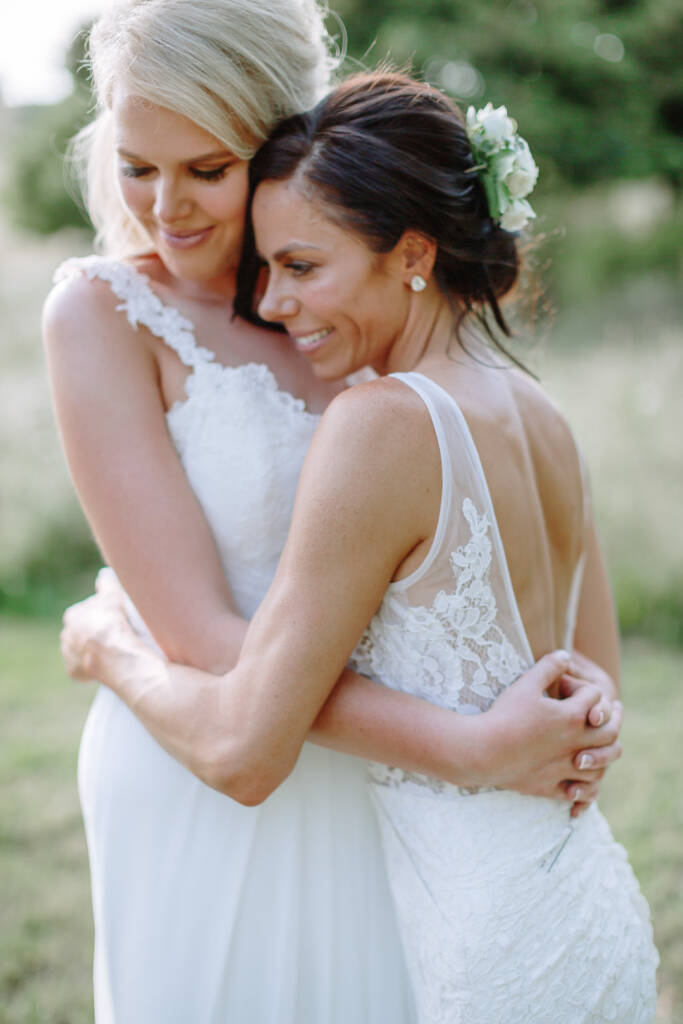 Ashlee and Kate smile while embracing during their couple portraits.