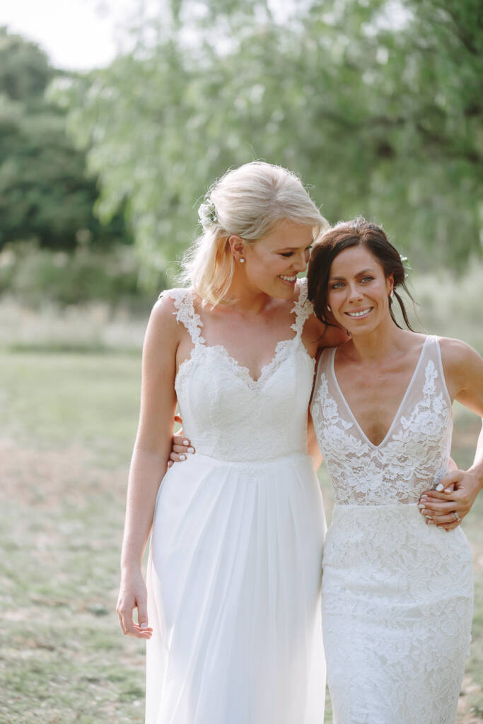 Ashlee smiles towards the camera as Kate looks at her during their couple portrait.