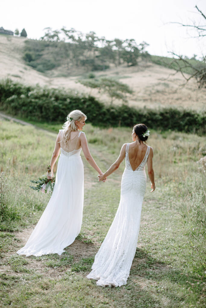 Ashlee and Kate look towards each other while walking along a paddock path at Riverstone Estate.