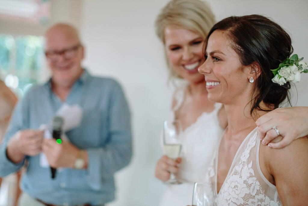 Ashlee smiles with Kate's arm around her shoulder as a guest reads a speech.