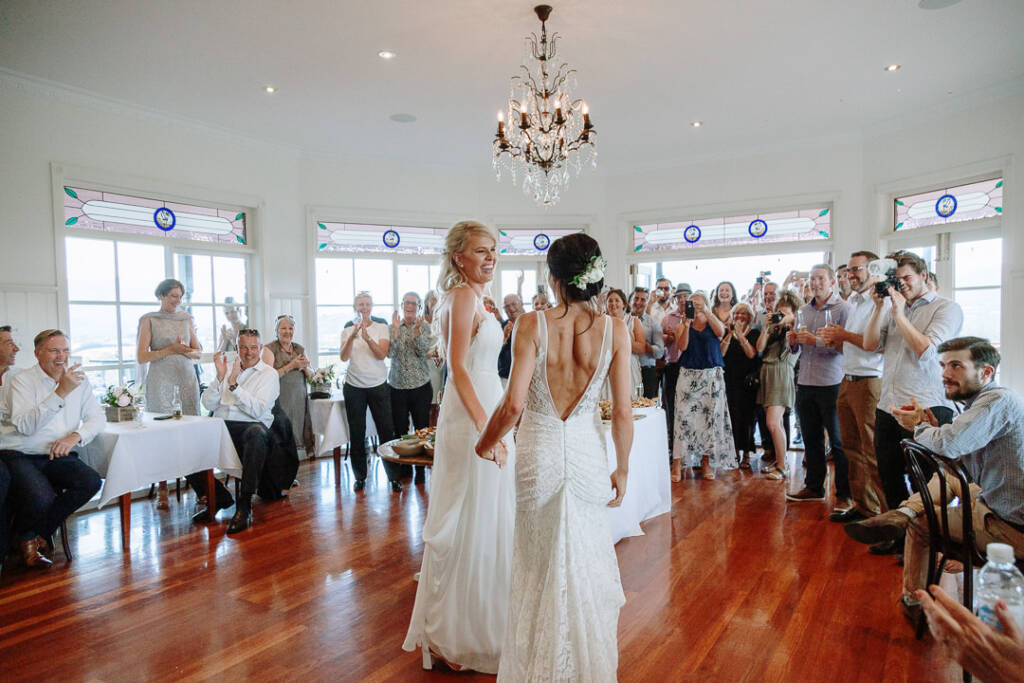 Guests applaud the couple beneath the chandelier in Riverstone's reception room.