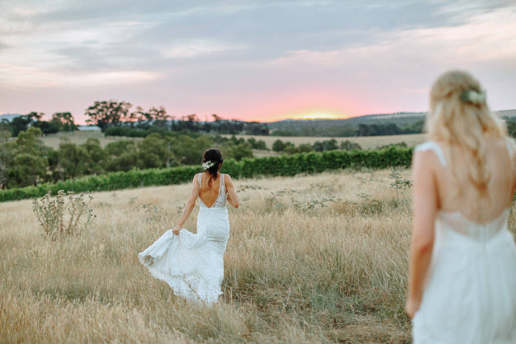 Ashlee walks ahead of Kate through the paddock for sunset photos at Riverstone Estate in the Yarra Valley.