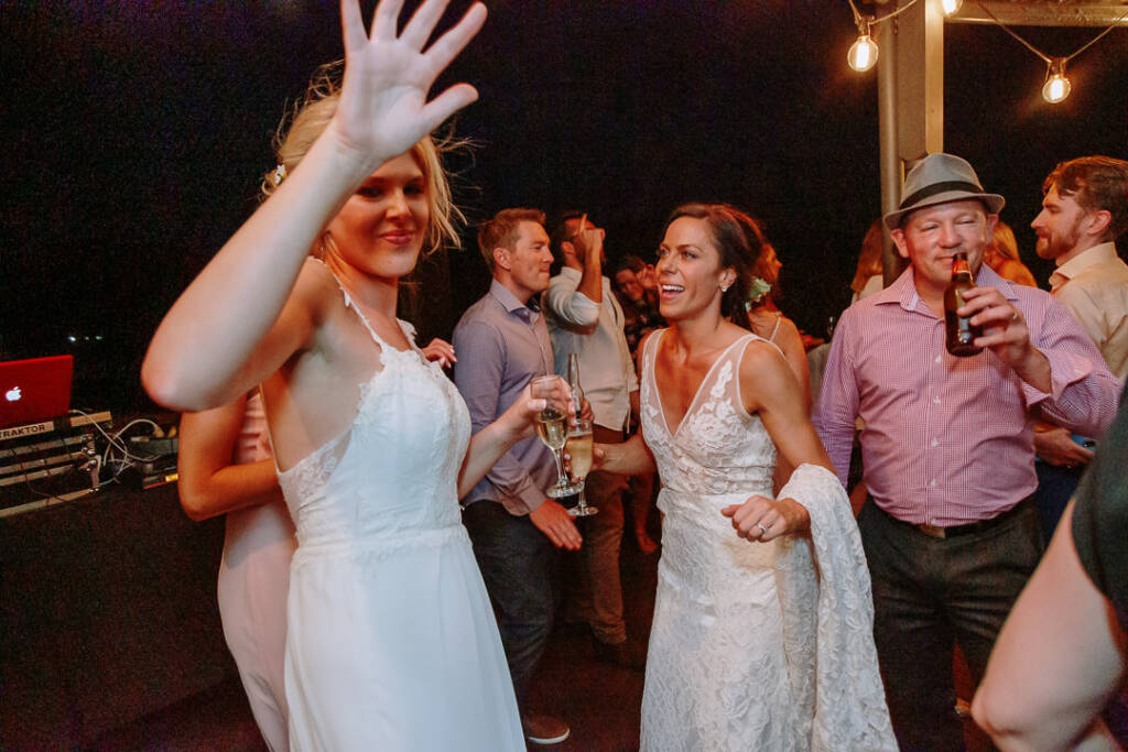 Ashlee and Kate dance among guests beneath the verandah festoon lights at Riverstone.