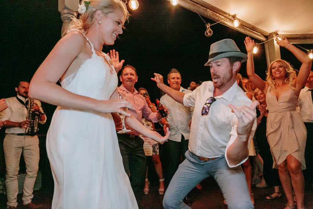 Kate dances opposite a guest in a hat as the saxophonist plays at Riverstone.