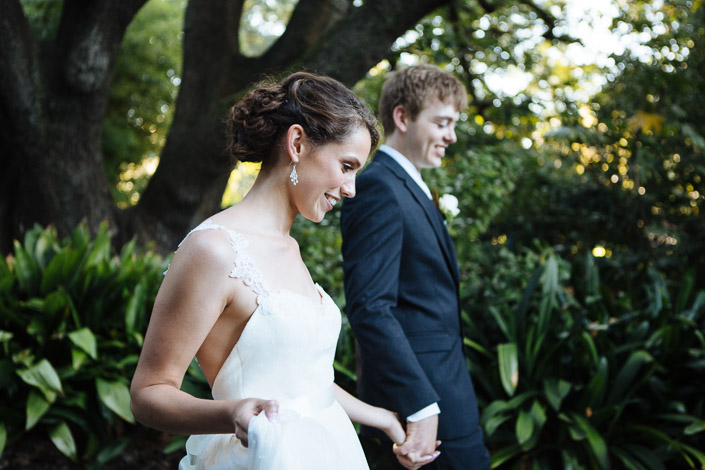 Frances leads Tim by the hand through garden beds, lifting her skirt and smiling to herself.