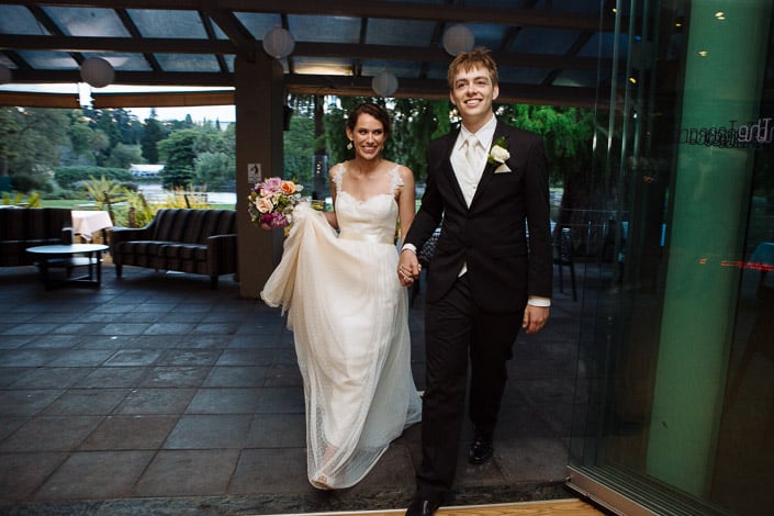 Paper lanterns hang above Frances and Tim as they walk hand in hand into The Terrace at dusk.