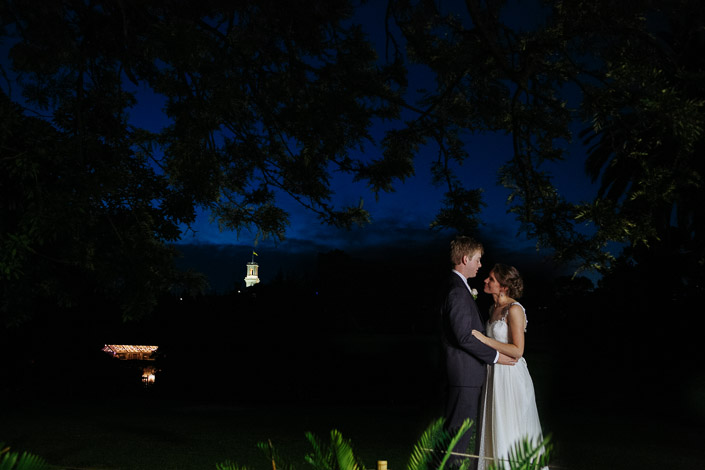 Night falls over the Royal Botanic Gardens as Frances and Tim hold each other beneath a lit tower.
