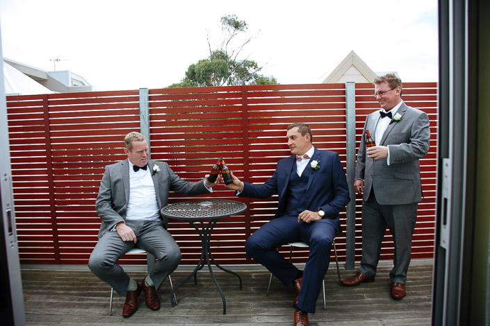 Beers clink over the little iron table on the red-slatted balcony