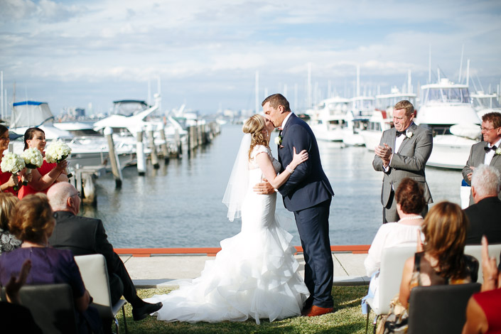 The first kiss on the lawn as applause rolls off the water