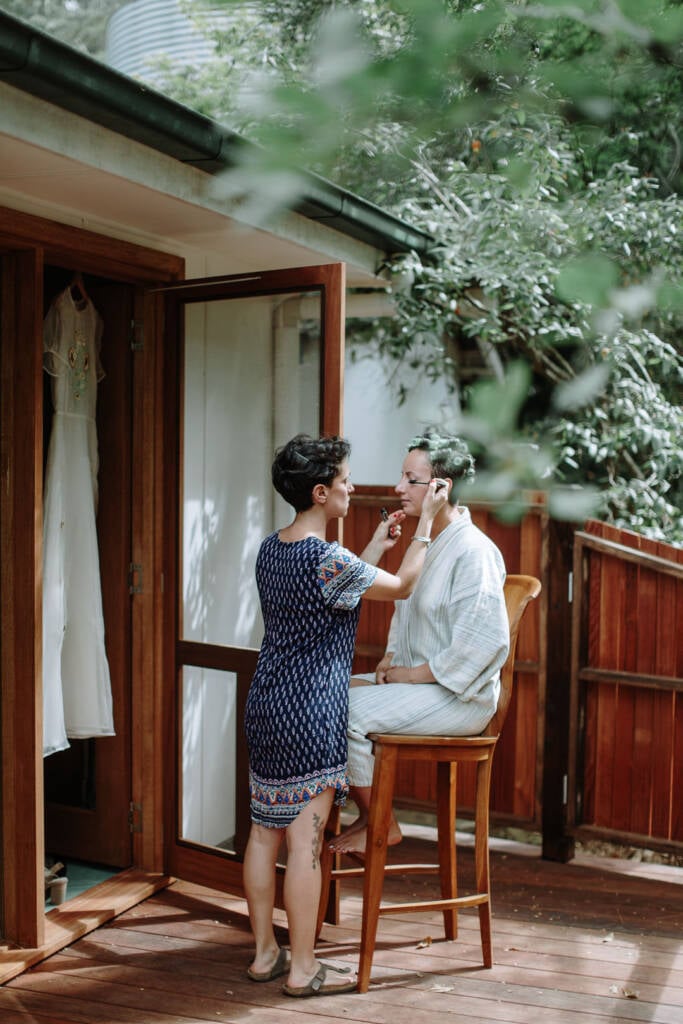 Sarah has her make-up applied on the verandah at Strathvea, with her gown hanging nearby.