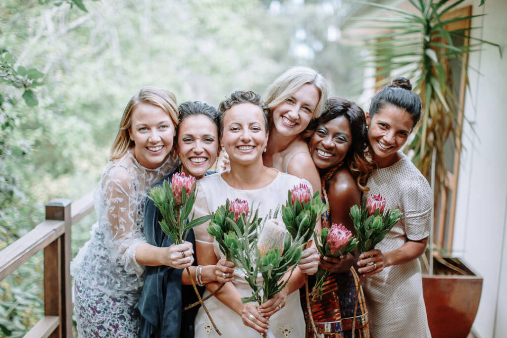 Sarah and her attendants pose in mismatched dresses with their bouquets at Strathvea Guesthouse.