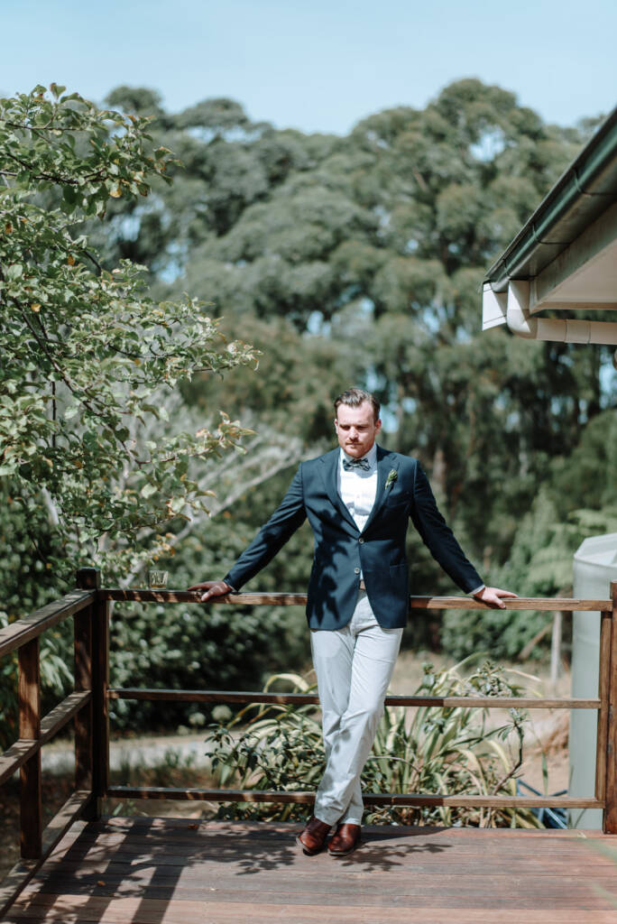 Jye leans against the timber verandah railing at Strathvea Guesthouse.
