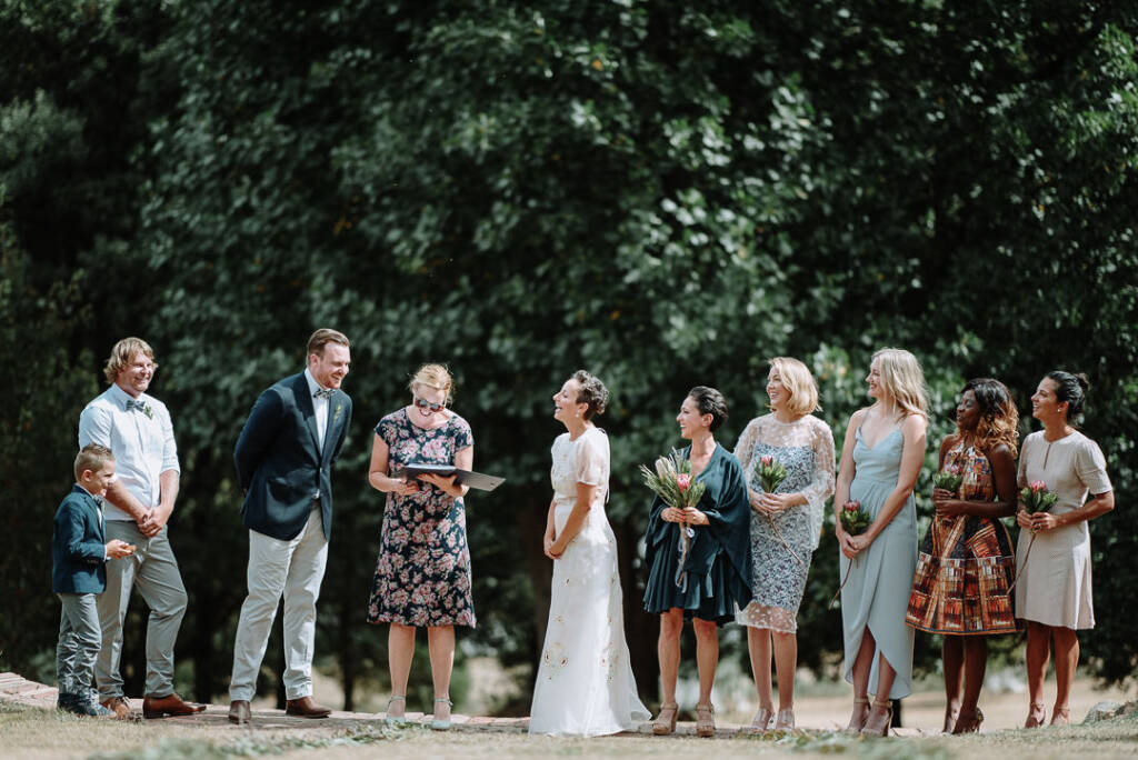 The couple share a smile beside their celebrant at Strathvea.