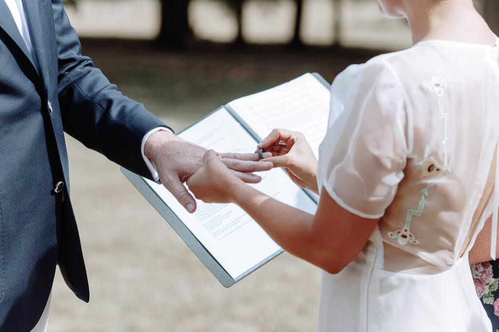 Sarah places a ring on Jye's finger during their ceremony at Strathvea Guesthouse.