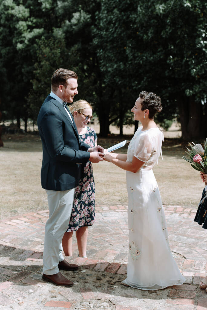 Jye holds Sarah's fingers during the ring exchange at Strathvea.