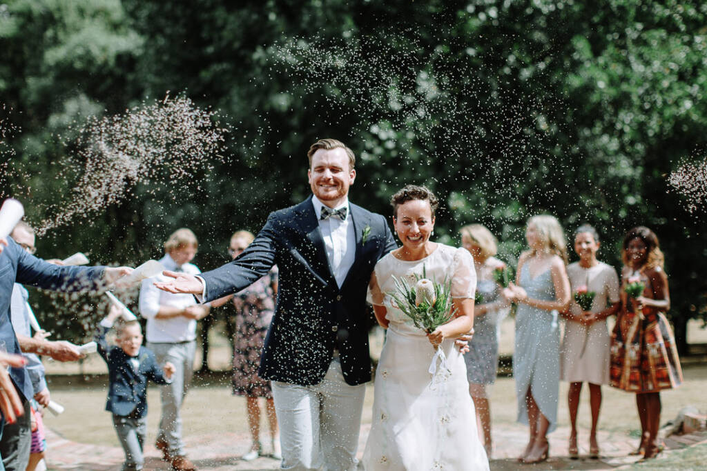 Sarah and Jye walk through a confetti shower after their Yarra Valley garden wedding at Strathvea.