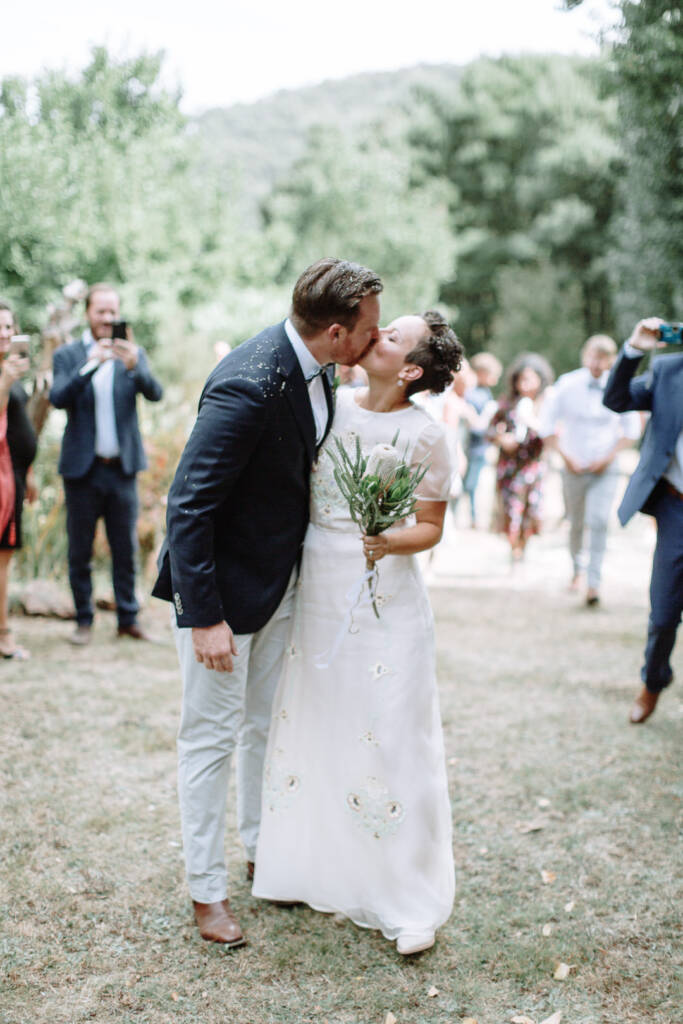 Sarah and Jye kiss in the aisle at Strathvea Guesthouse.