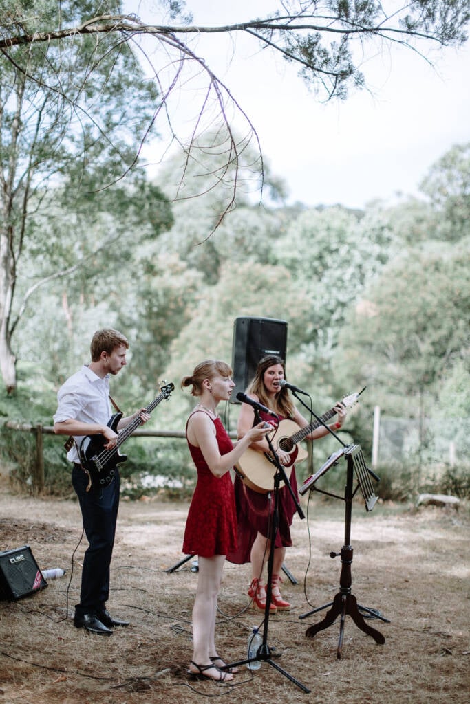 A live trio performs with bass and acoustic guitar in the garden at Strathvea.
