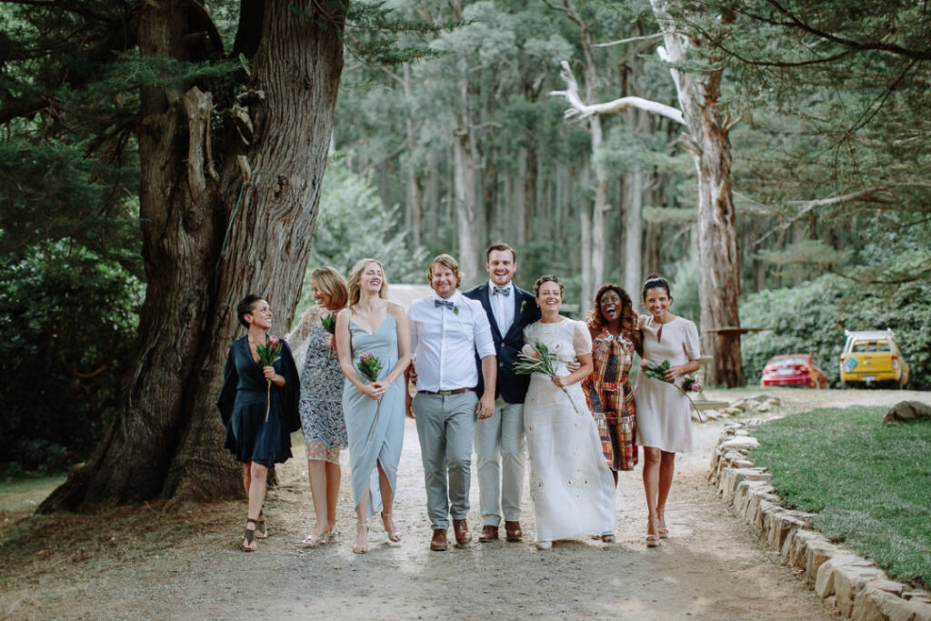 Sarah, Jye and their wedding party walk along the drive at Strathvea.