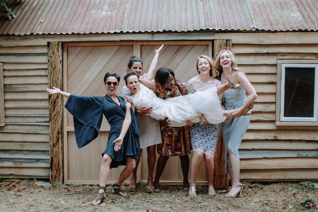 Sarah laughs as her attendants carry her during a wedding-party portrait.