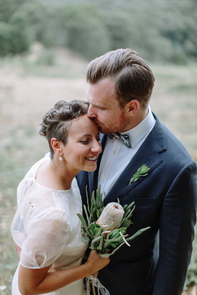 Jye kisses Sarah's forehead during their couple portraits.