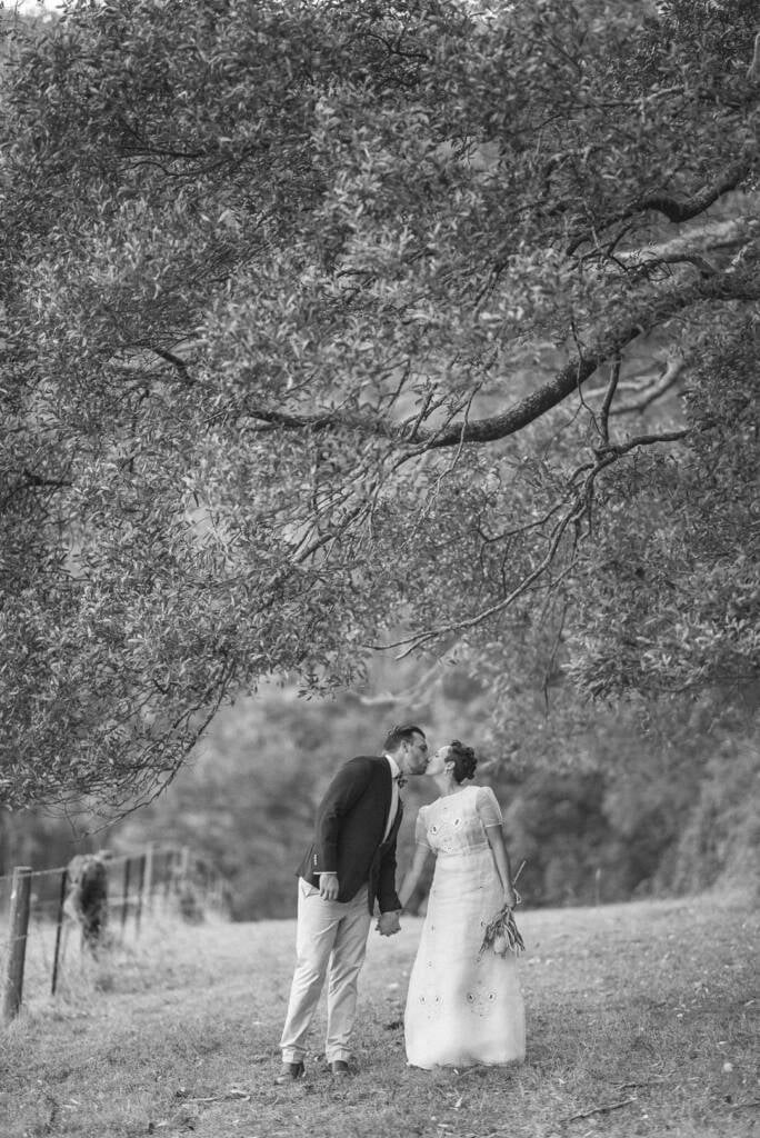 Black-and-white portrait of Sarah and Jye kissing.