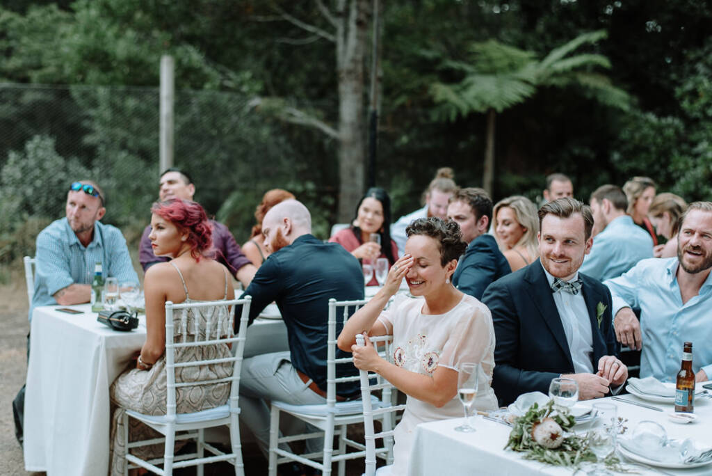 Sarah touches her forehead while laughing during the reception.