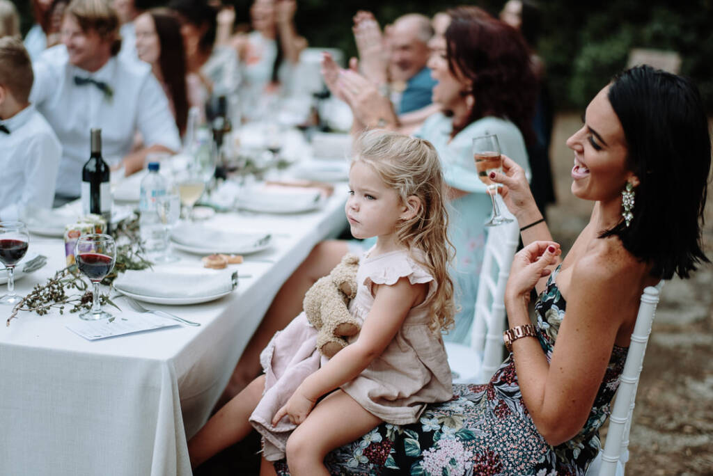A child sits on an adult's lap with a soft toy during the reception.