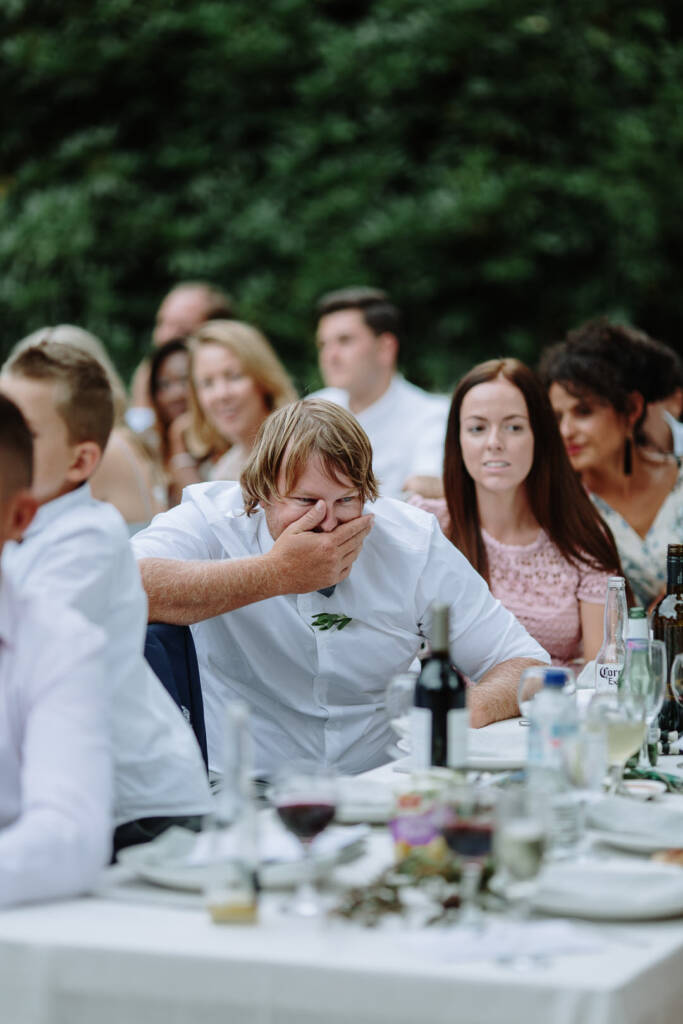 An attendant covers their mouth with a hand while listening to the speeches.