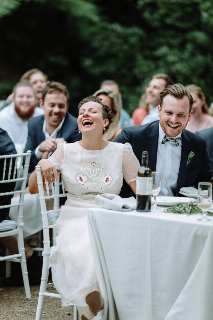 Sarah and Jye laugh together during the reception speeches.
