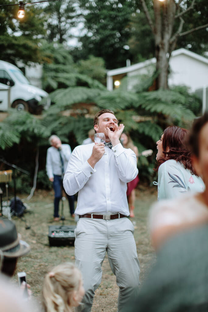 Jye cups his hand beside his mouth as he cheers during the reception.