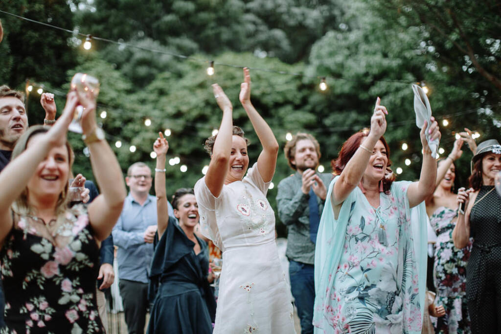 Sarah and guests clap overhead on the outdoor dance floor at Strathvea Guesthouse.