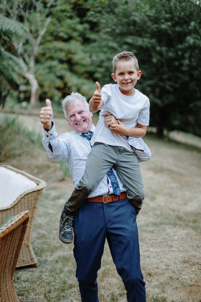 A guest lifts a child into the air while giving a thumbs-up.