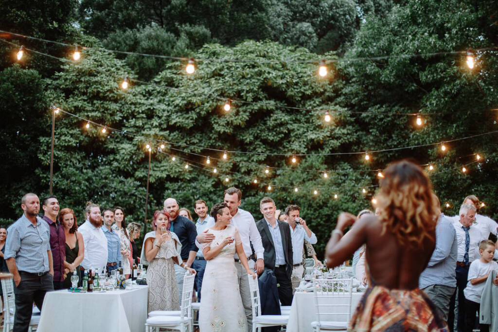 An attendant addresses Sarah and Jye as they stand together at the reception.