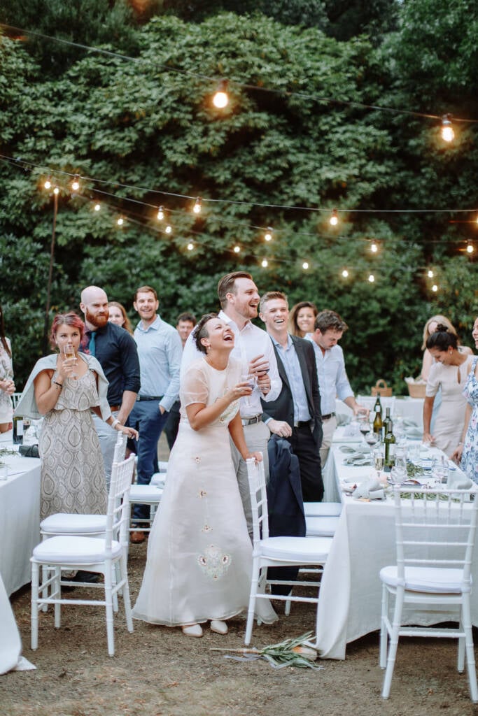 Sarah and Jye laugh together with drinks in hand.