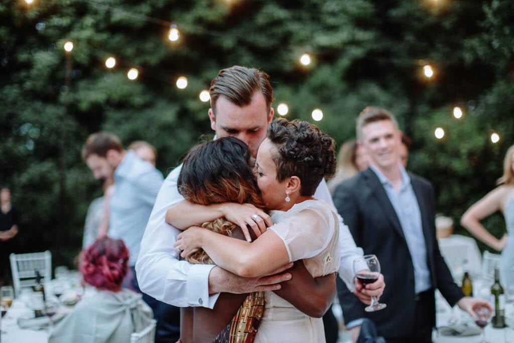 Sarah and Jye hug an attendant together after the speech.