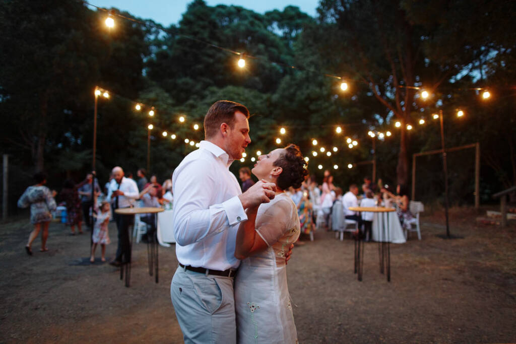 The couple dance on the outdoor floor at Strathvea as guests watch from the dining tables.