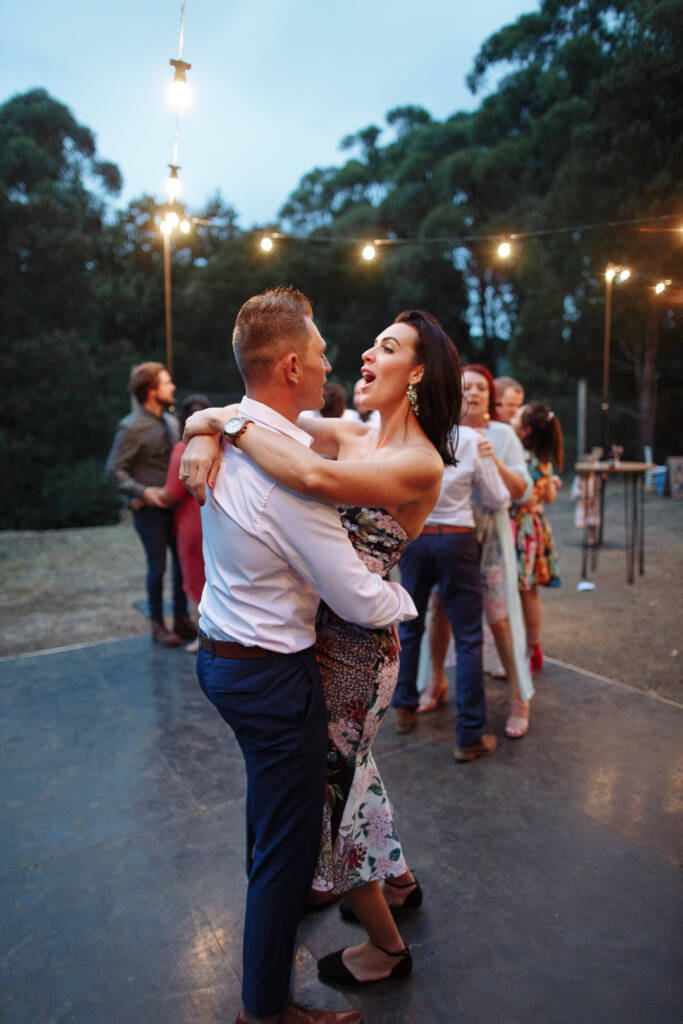 Two guests dance in close hold beneath the festoon lights at Strathvea.