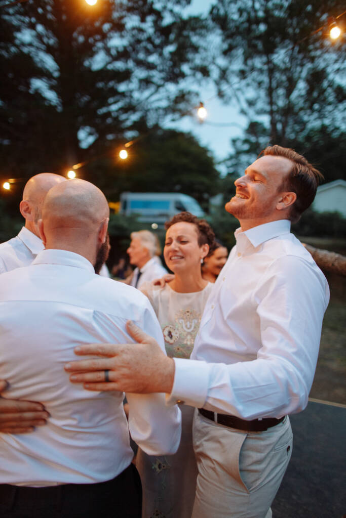 Sarah, Jye and their guests gather with their arms around each other at Strathvea Guesthouse.