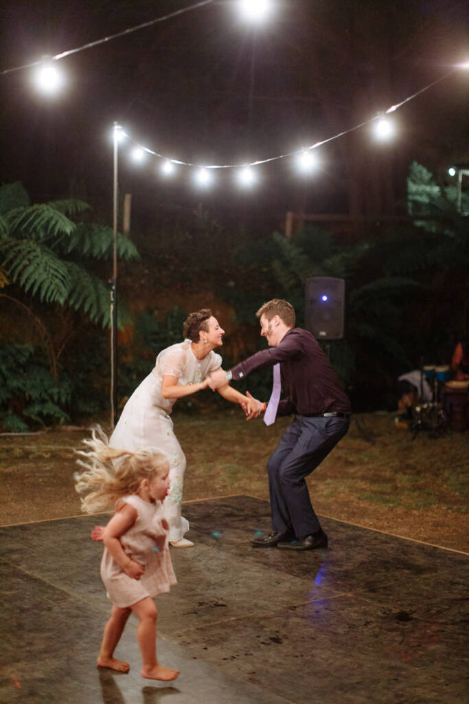 Sarah dances with a guest as a child crosses the outdoor dance floor at Strathvea Guesthouse.