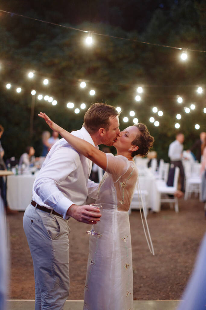 Sarah and Jye kiss while dancing beneath the festoon lights at Strathvea.