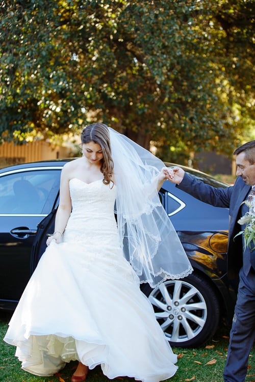 Shannon steps from a black car onto the lawn at Sunnybrae, holding a man's hand.