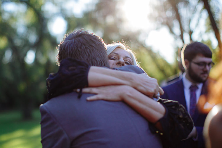 A blonde-haired woman smiles while hugging Luke.