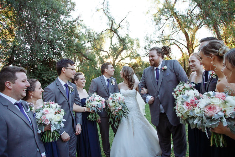 Shannon and Luke stand with their wedding party on the lawn at Sunnybrae Estate.