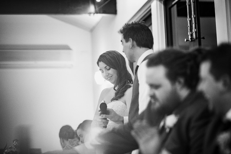 Black-and-white photo of Shannon holding a microphone while standing beside Luke.